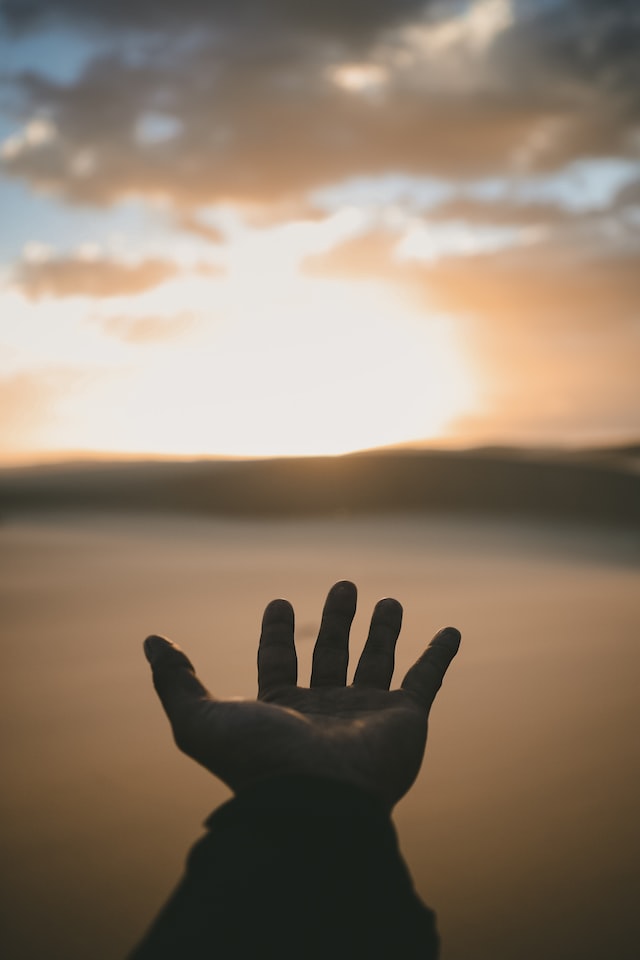 ausgestreckte Hand vor Sonnenaufgang