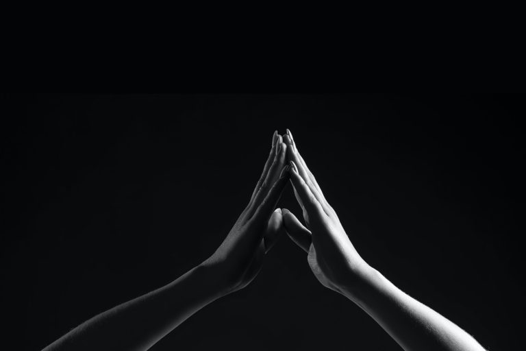 zwei Hände, die sich an den Fingerspitzen berühren