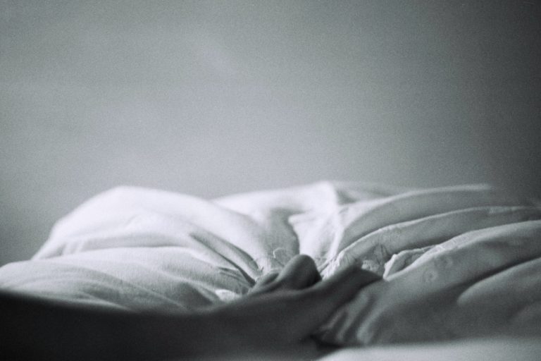 Hand auf weißem Bettlaken